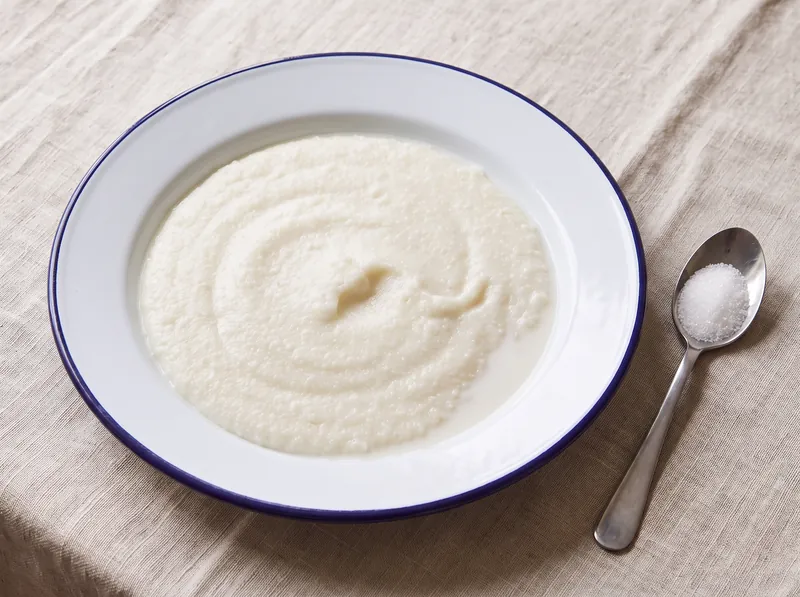 A bowl of soft white maize porridge with milk