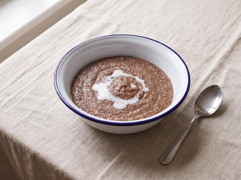 A bowl of brown finger millet porridge with a little milk